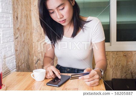 Asia woman using credit card and smart phone in Asia woman using credit card and smart phone in 58205887