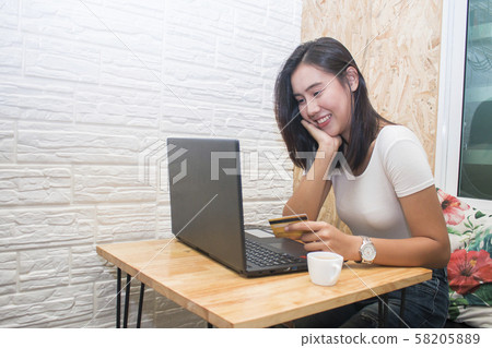Smiling asian woman holding credit card Smiling asian woman holding credit card 58205889