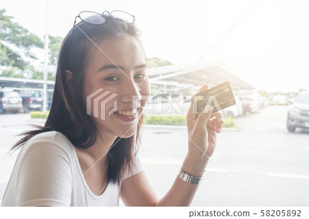 Smiling asian young female model holding up credit 58205892