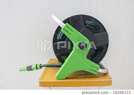 Nozzle of gardening water hose on concrete 58206131