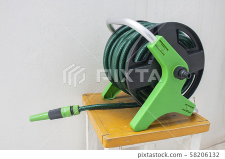 Nozzle of gardening water hose on concrete 58206132