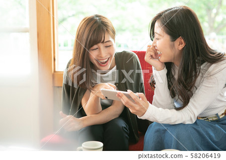 Female duo relaxing at the cafe 58206419