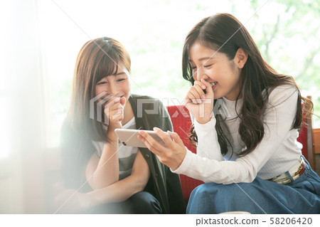 Female duo relaxing at the cafe Female duo relaxing at the cafe 58206420