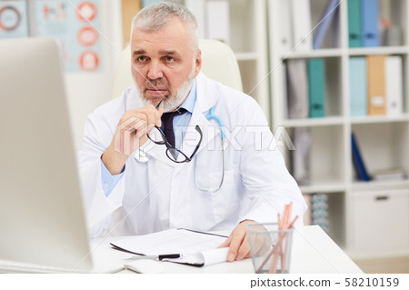 Male doctor working at office 58210159