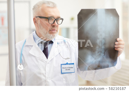 Doctor examining x-ray image Doctor examining x-ray image 58210187