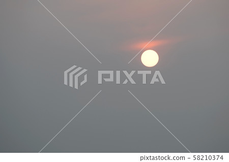 Sunrise sky covered with haze , making it look unusual Sunrise sky covered with haze , making it look unusual 58210374