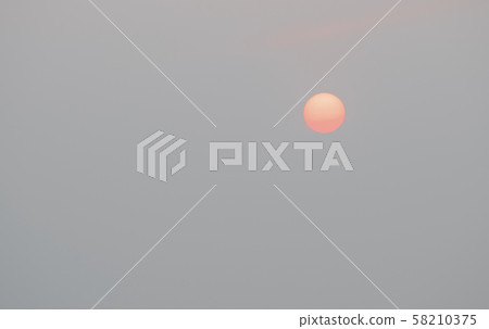 Sunrise sky covered with haze , making it look unusual Sunrise sky covered with haze , making it look unusual 58210375