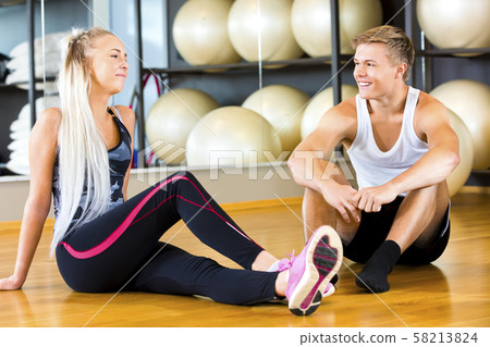 Smiling Young Man And Woman Sitting In Gym Smiling Young Man And Woman Sitting In Gym 58213824