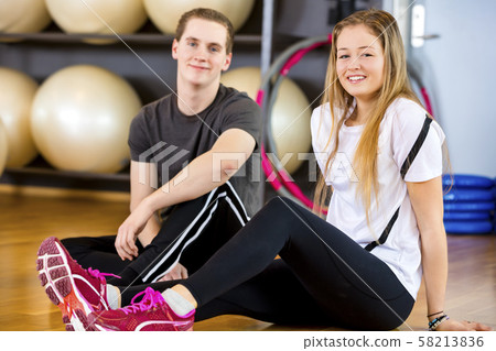 Two smiling workout friends having a break at the fitness gym 58213836