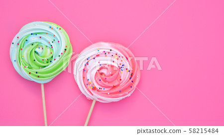 Colorful meringue lollipop on a pink background. Colorful meringue lollipop on a pink background. 58215484