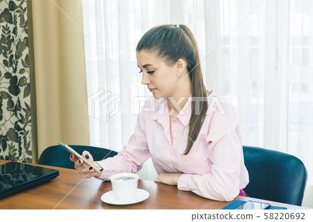 A young woman during a break in the workplace A young woman during a break in the workplace 58220692