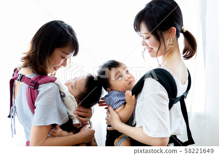 Mom friends holding an infant Mom friends holding an infant 58221649