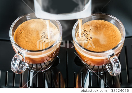freshly brewed coffee is poured from the coffee machine freshly brewed coffee is poured from the coffee machine 58224056