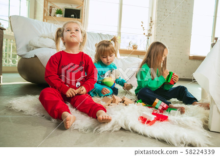 Little girls in soft warm pajamas playing at home 58224339