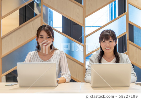 便攜式計算機上工作的兩個女人 便攜式計算機上工作的兩個女人 58227199