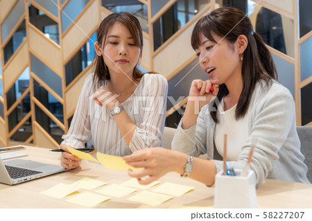 Two women working with sticky notes Two women working with sticky notes 58227207