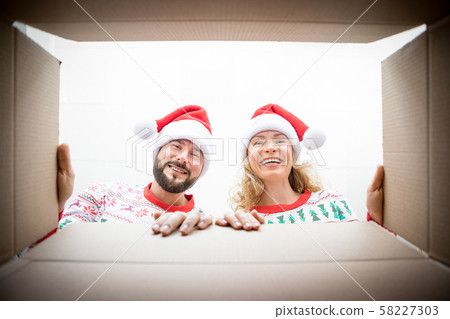 Surprised couple unpack Christmas gift box Surprised couple unpack Christmas gift box 58227303