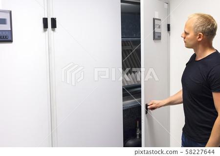 Technician Opening Air Conditioner Cabinet In Datacenter 58227644