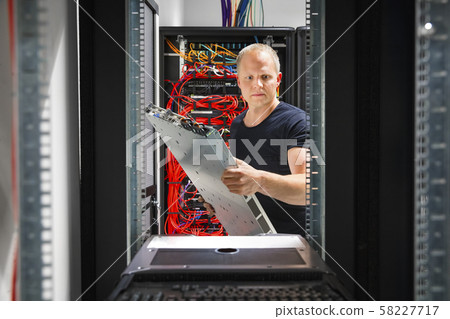 IT Engineer Arranging Server At Datacenter IT Engineer Arranging Server At Datacenter 58227717