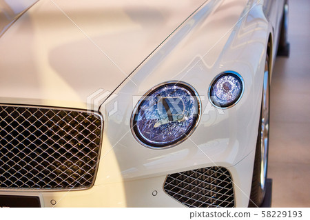 Headlight detail of luxury car. Closeup of sedan headlamp. Car headlight background Headlight detail of luxury car. Closeup of sedan headlamp. Car headlight background 58229193