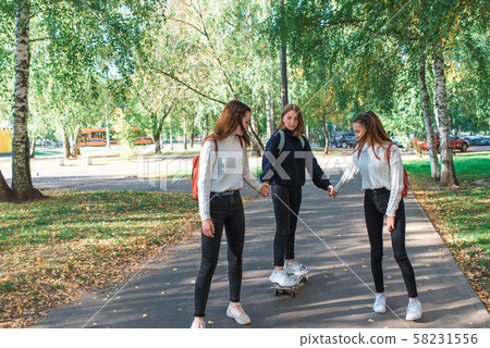 Teenage girls in sweaters, 3 schoolgirls girlfriends, summer in autumn and spring in city Teenage girls in sweaters, 3 schoolgirls girlfriends, summer in autumn and spring in city 58231556