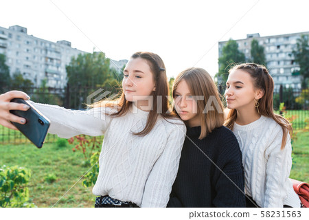Teenage girls in summer autumn spring in city, take pictures on smartphone, on-line application on 58231563