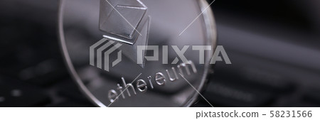 Silver ethereum coin is lying on laptop 58231566