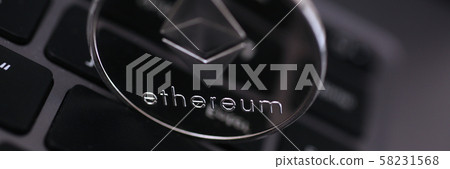 Silver ethereum coin is lying on laptop 58231568