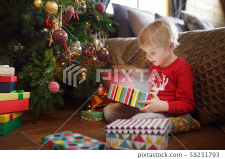 Cute little boy opening a Christmas gift. Portrait Cute little boy opening a Christmas gift. Portrait 58231793