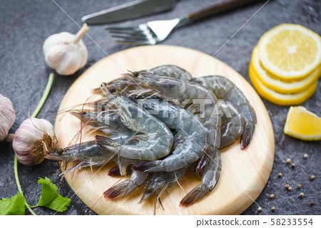 raw shrimps on wooden cutting board plate - fresh raw shrimps on wooden cutting board plate - fresh 58233554