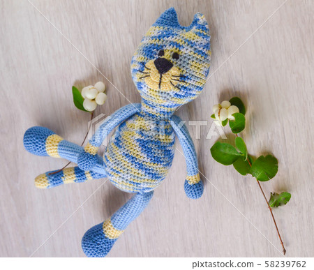 Knitted blue striped handmade crafted cat. Knitted blue striped handmade crafted cat. 58239762