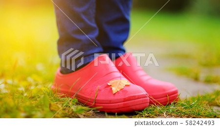 Close up photo of woman legs in rubber shoes Close up photo of woman legs in rubber shoes 58242493