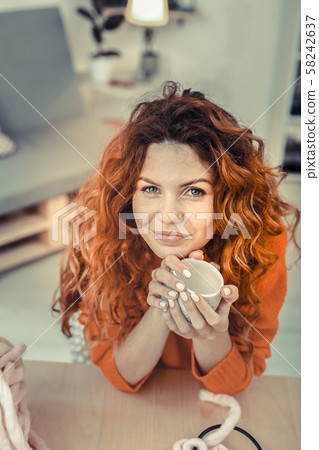 Kind cute girl leaning her elbows on a table Kind cute girl leaning her elbows on a table 58242637