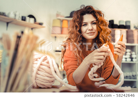 Positive delighted long-haired female demonstrating her hobby Positive delighted long-haired female demonstrating her hobby 58242646