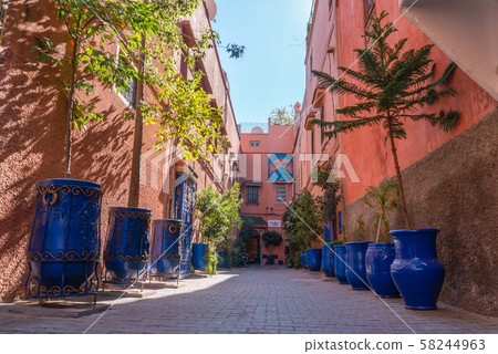 picturesque street in Marrakesh city with plants in blue vases and painted cobbles picturesque street in Marrakesh city with plants in blue vases and painted cobbles 58244963