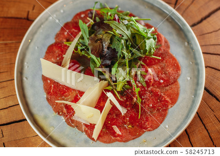 portion of carpaccio with cheese and arugula portion of carpaccio with cheese and arugula 58245713