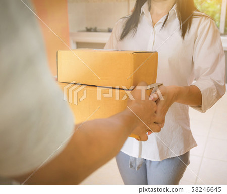 Technology delivery staff uniform handing a parcel box receiving parcel from delivery Technology delivery staff uniform handing a parcel box receiving parcel from delivery 58246645