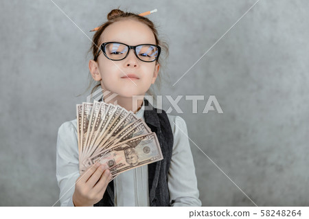 The lady's small business is on a gray background. Close-up During this, holds the money in hand. The lady's small business is on a gray background. Close-up During this, holds the money in hand. 58248264
