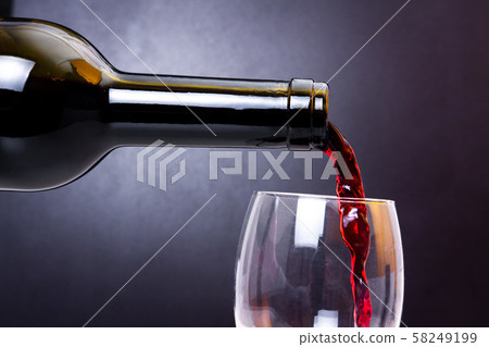 Red wine pours into glass close-up. Wine pouring 58249199
