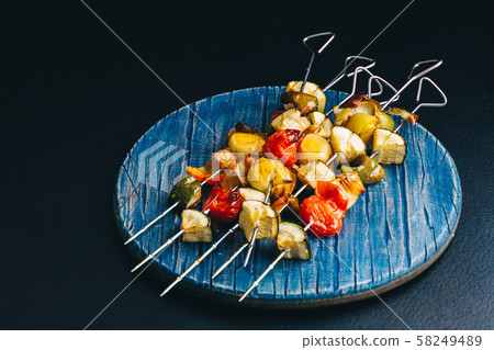 Metal skewers with grilled vegetables on the board Metal skewers with grilled vegetables on the board 58249489
