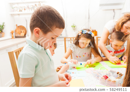 Cute boy makes a detail for his postcard in a masterclass Cute boy makes a detail for his postcard in a masterclass 58249511