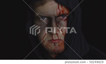 Man executioner Halloween makeup and costume. Guy with blood on his face 58249829