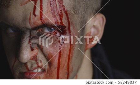 Halloween man portrait. Guy with dripping blood on his face. Scary makeup Halloween man portrait. Guy with dripping blood on his face. Scary makeup 58249837