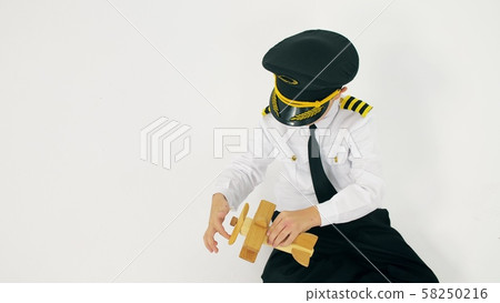 Boy in pilot's uniform plays with a toy plane propeller Boy in pilot's uniform plays with a toy plane propeller 58250216