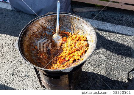 Traditional Uzbek pilaf in a large cauldron Traditional Uzbek pilaf in a large cauldron 58250501