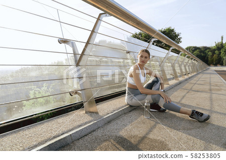 Calm lady in sport wear sitting on bridge road 58253805