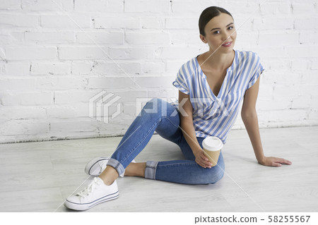 Pretty woman by the wall on the floor stock photo 58255567