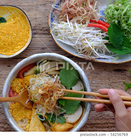 people eating Vietnamese vegan rieu noodle soup or vegetarian crab paste vermicelli soup people eating Vietnamese vegan rieu noodle soup or vegetarian crab paste vermicelli soup 58256769