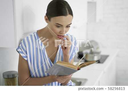 Young woman fascinated by interesting literature stock photo 58256813