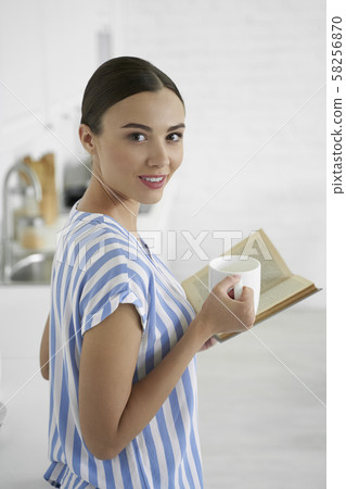 Woman with cup of tea and favorite book stock photo Woman with cup of tea and favorite book stock photo 58256870